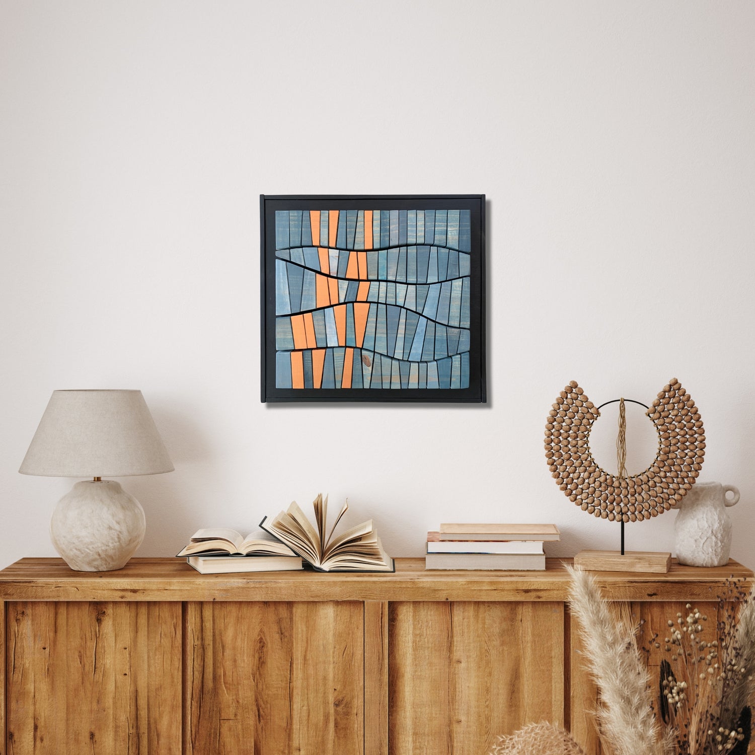 Framed wooden wall art titled “Inspired by a Koi Pond,” featuring abstract curved lines and a geometric design in soft blue and warm bronze tones. Handcrafted and painted to evoke the movement of water and koi fish, displayed in a serene, earth-toned interior above a wooden sideboard with natural decor.