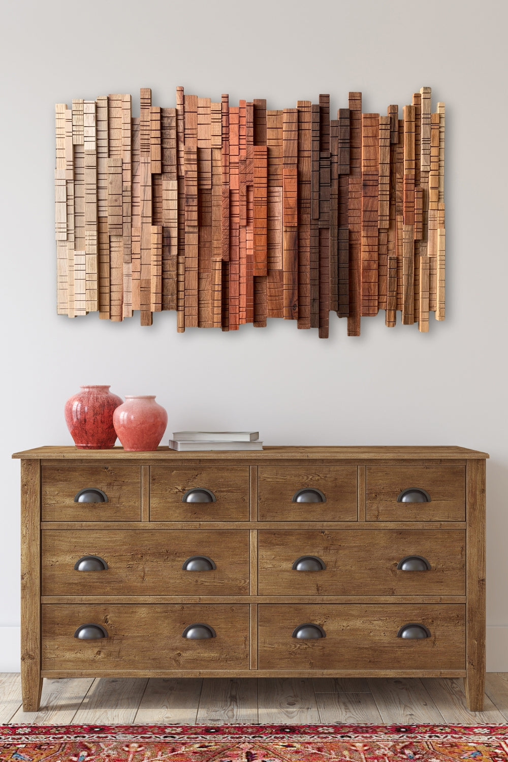 "A Walk Through the Forest” sculptural wood wall art with layered, grooved slats in cream-to-rust tones, styled above a wooden dresser in a calm interior.
