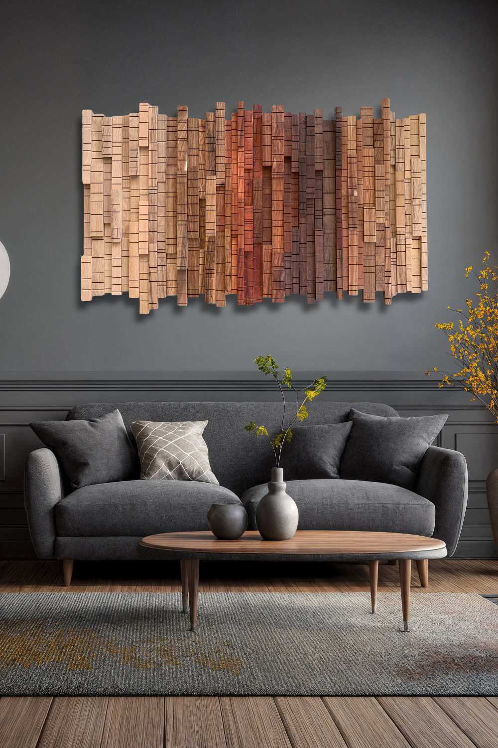 Sculptural wooden wall art from the A Walk Through the Forest collection displayed above a grey sofa in a dark modern living room.