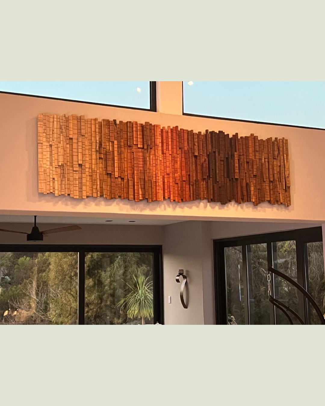 Bespoke architectural wood wall art illuminated by warm interior lighting in a contemporary home.