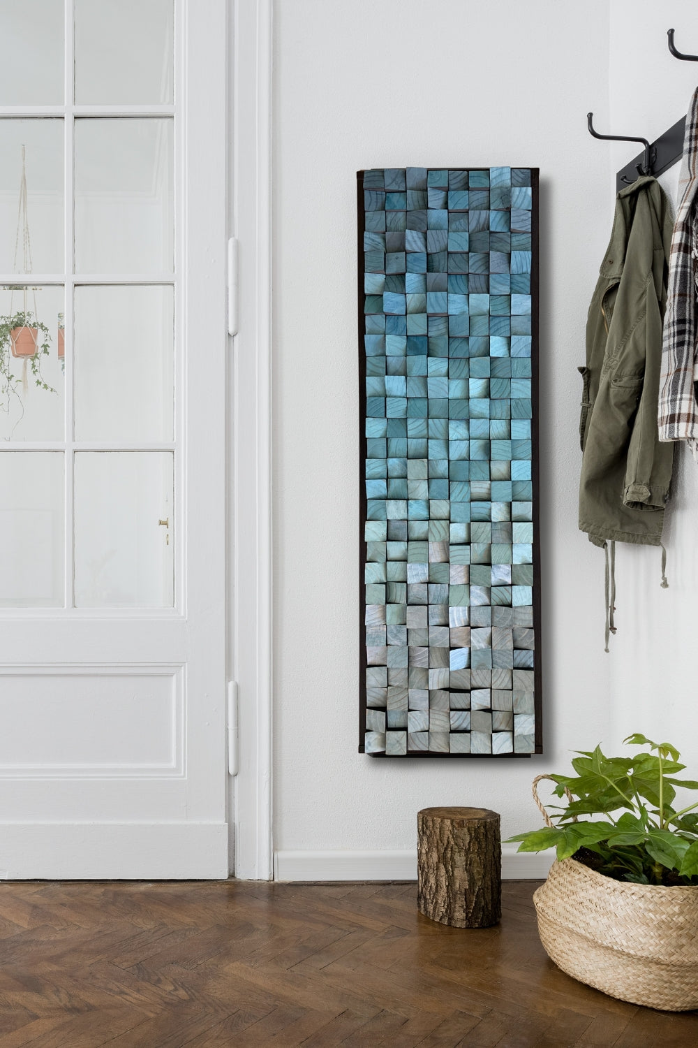 Blue vertical wooden wall art with a liquid metal paint finish displayed in a light entryway interior, showing raised texture, cool blue tones, and natural wood detail.