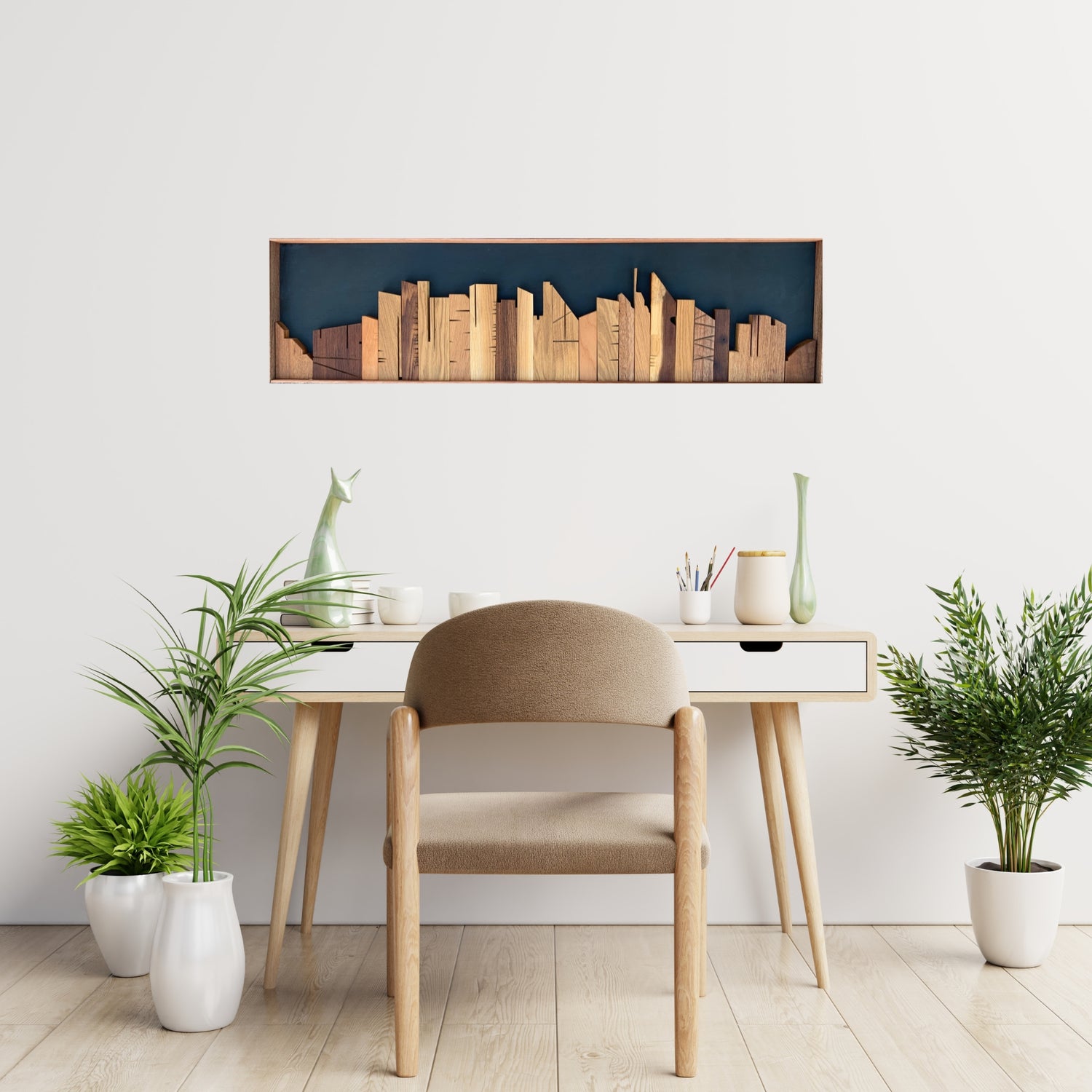 Cityscape wooden wall art above a desk in a light modern home office interior.