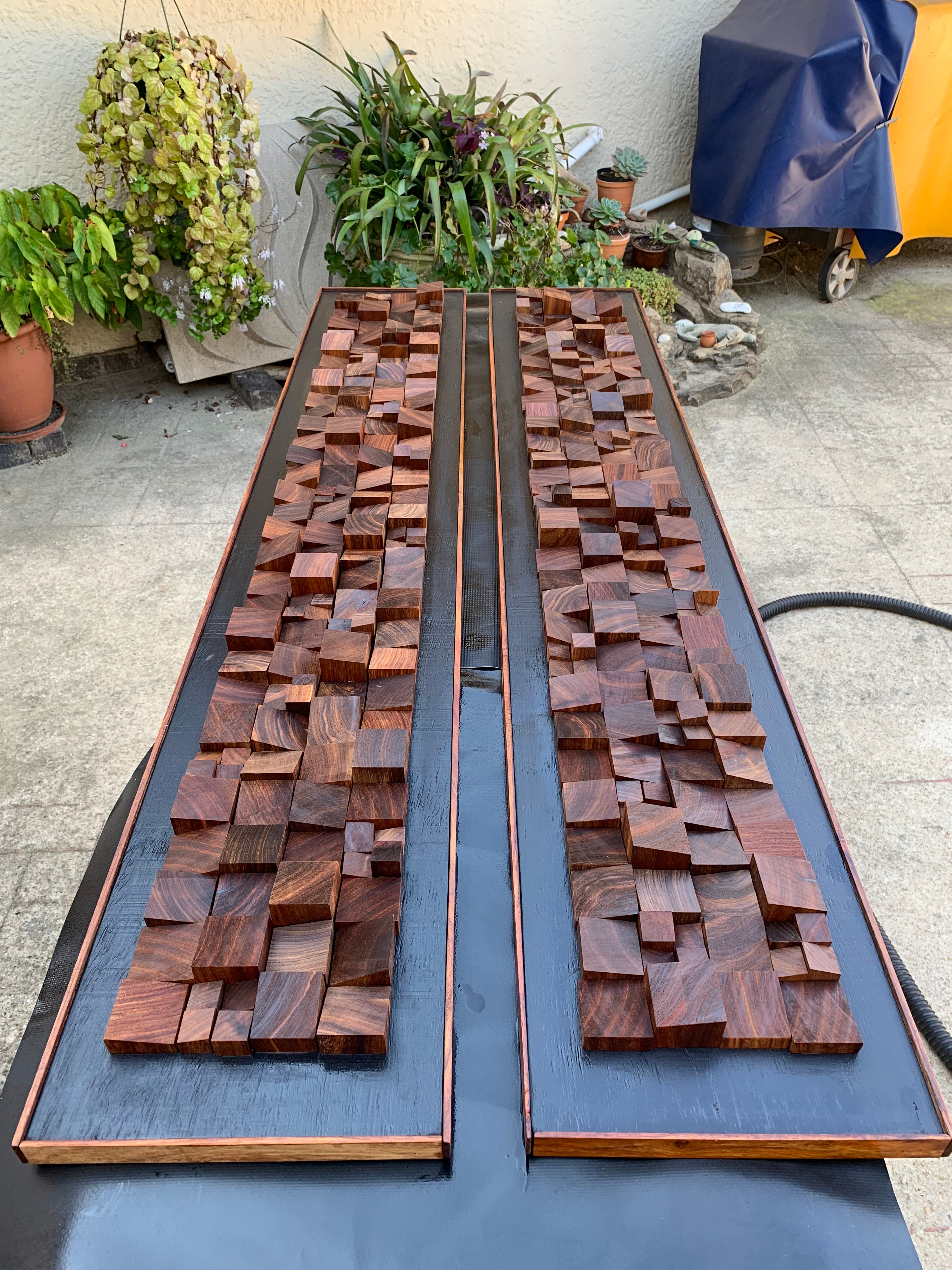 Pair of custom Kiaat wood wall panels photographed outdoors after oil treatment, ready for client delivery