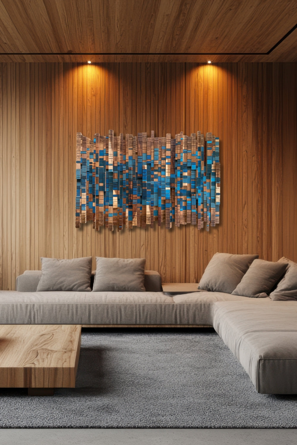 Forest Stream sculptural wooden wall art with blue painted accents displayed on a wood-panelled wall above a neutral sofa.