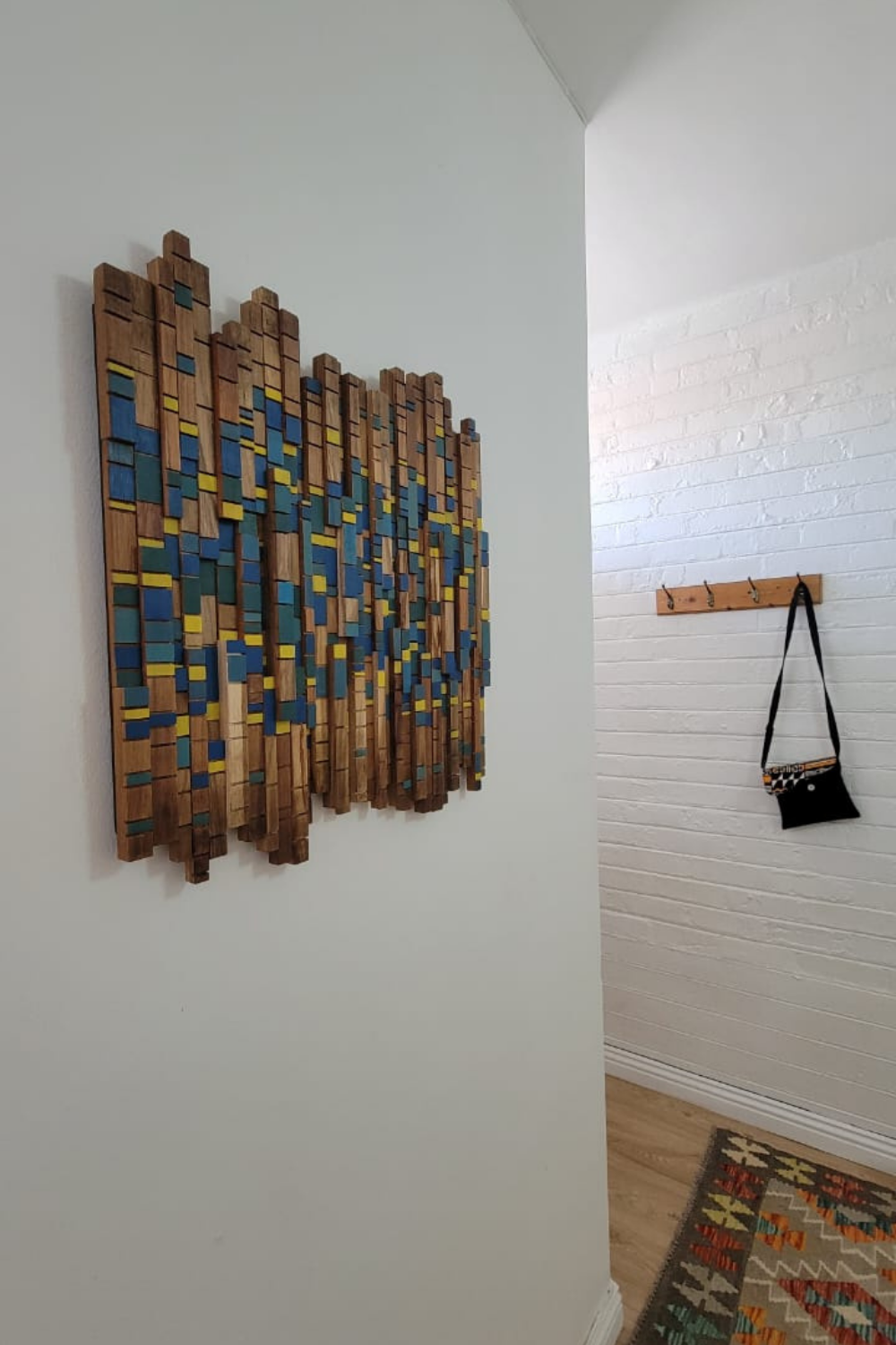 Custom Forest Sunstream wooden wall art with teal and yellow painted accents, inspired by the original Forest Stream piece and installed in a client’s home.