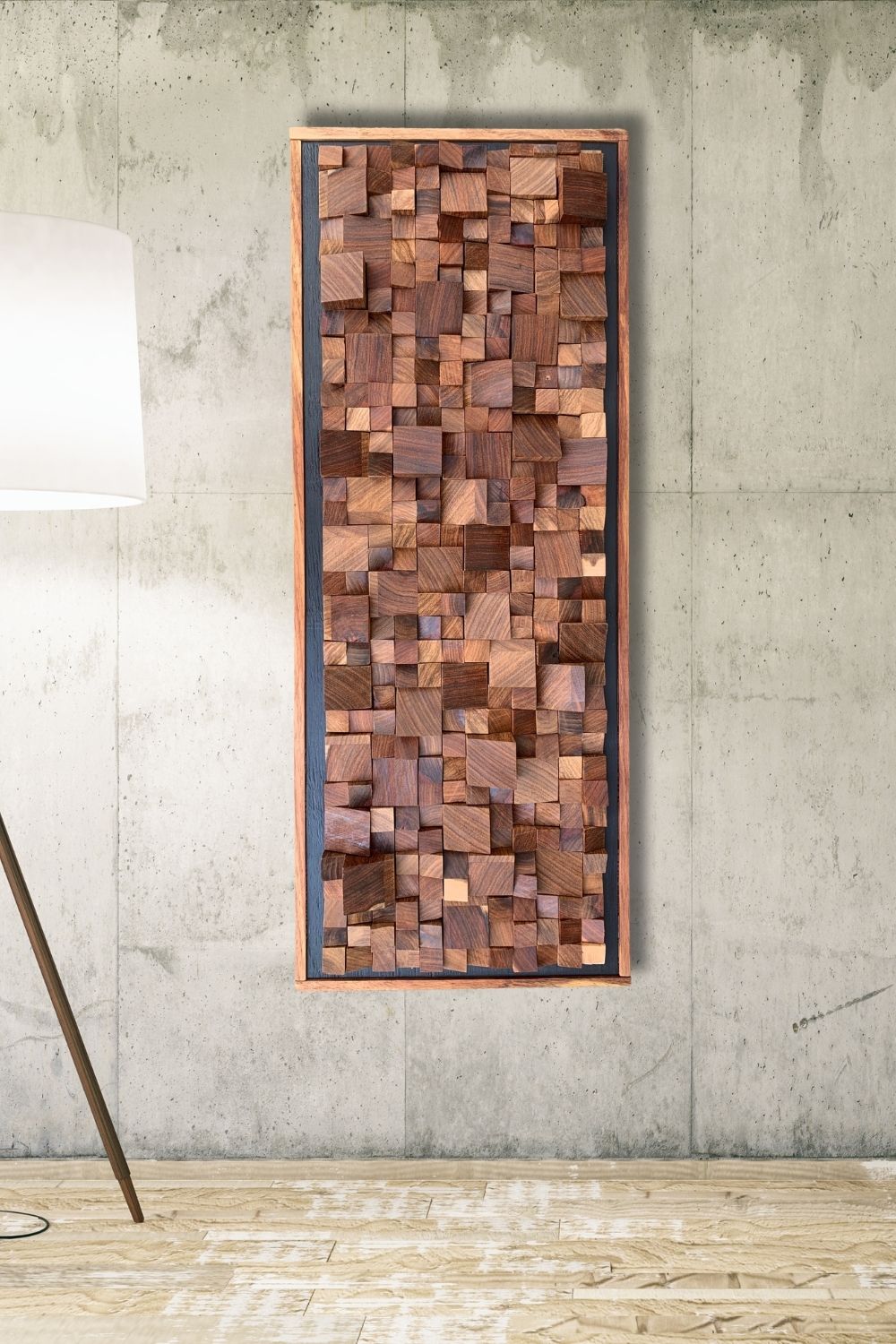 Framed Kiaat wood mosaic wall art displayed on a concrete wall, showing the raised block texture and natural wood tones.