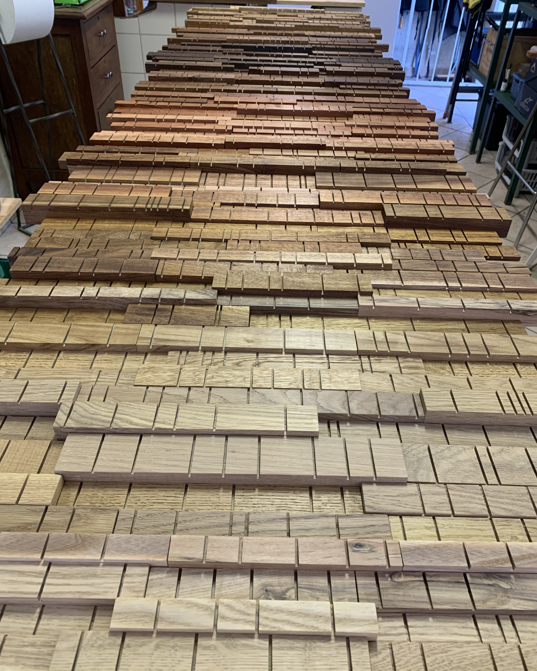 Large bespoke wooden wall artwork during assembly in the workshop before final installation.