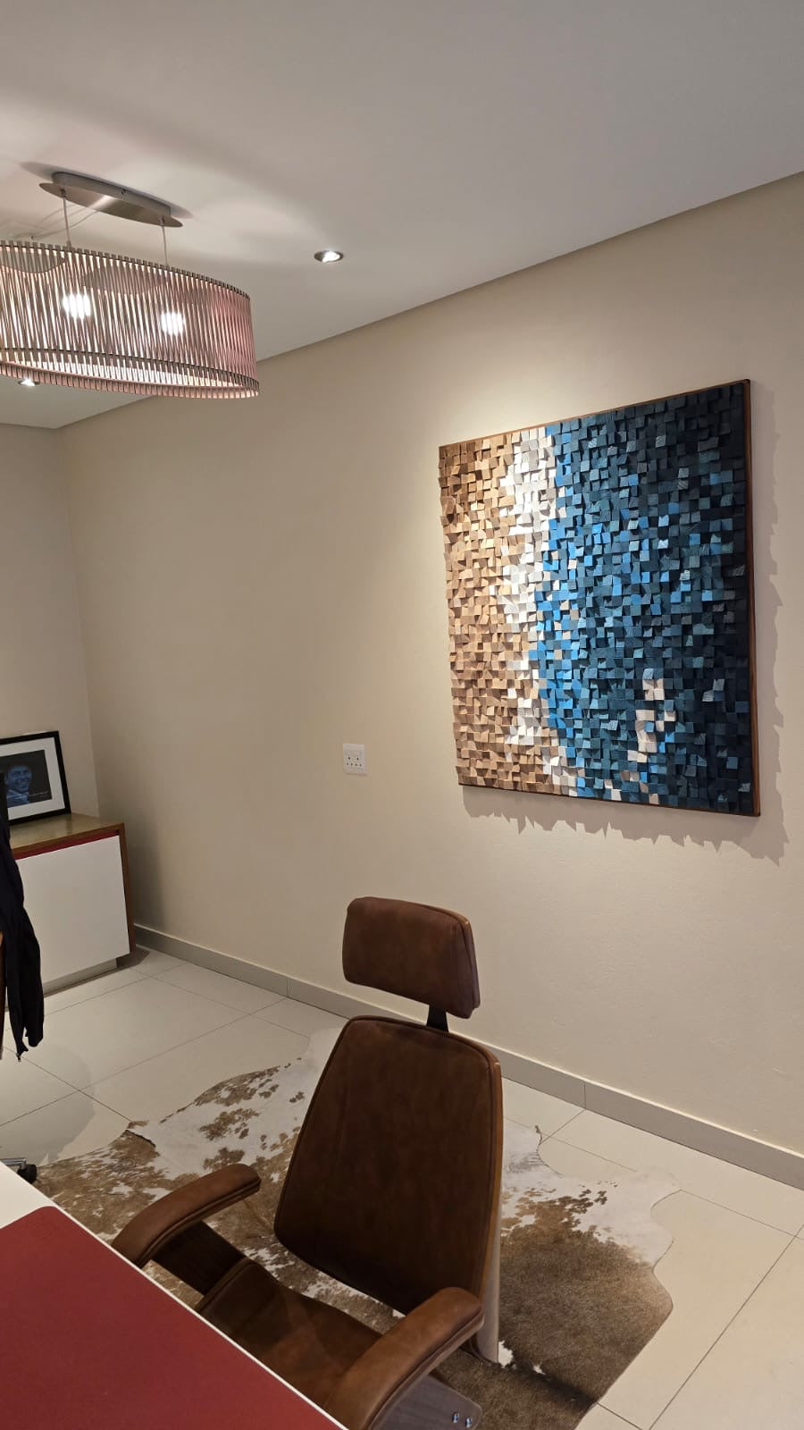 Installed view of custom sculptural wood wall art for House Keller – decorative sound diffuser inspired by a beach scene in blue, white, and natural tones”
