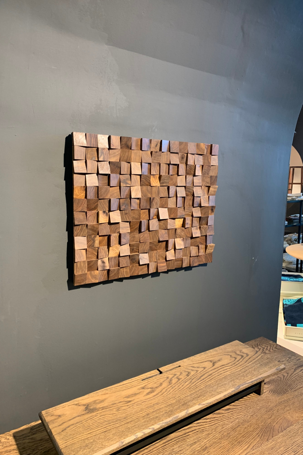 Handcrafted Kiaat textured block wall art installed above a console table, showing warm wood tones, raised blocks and sculptural timber detail.