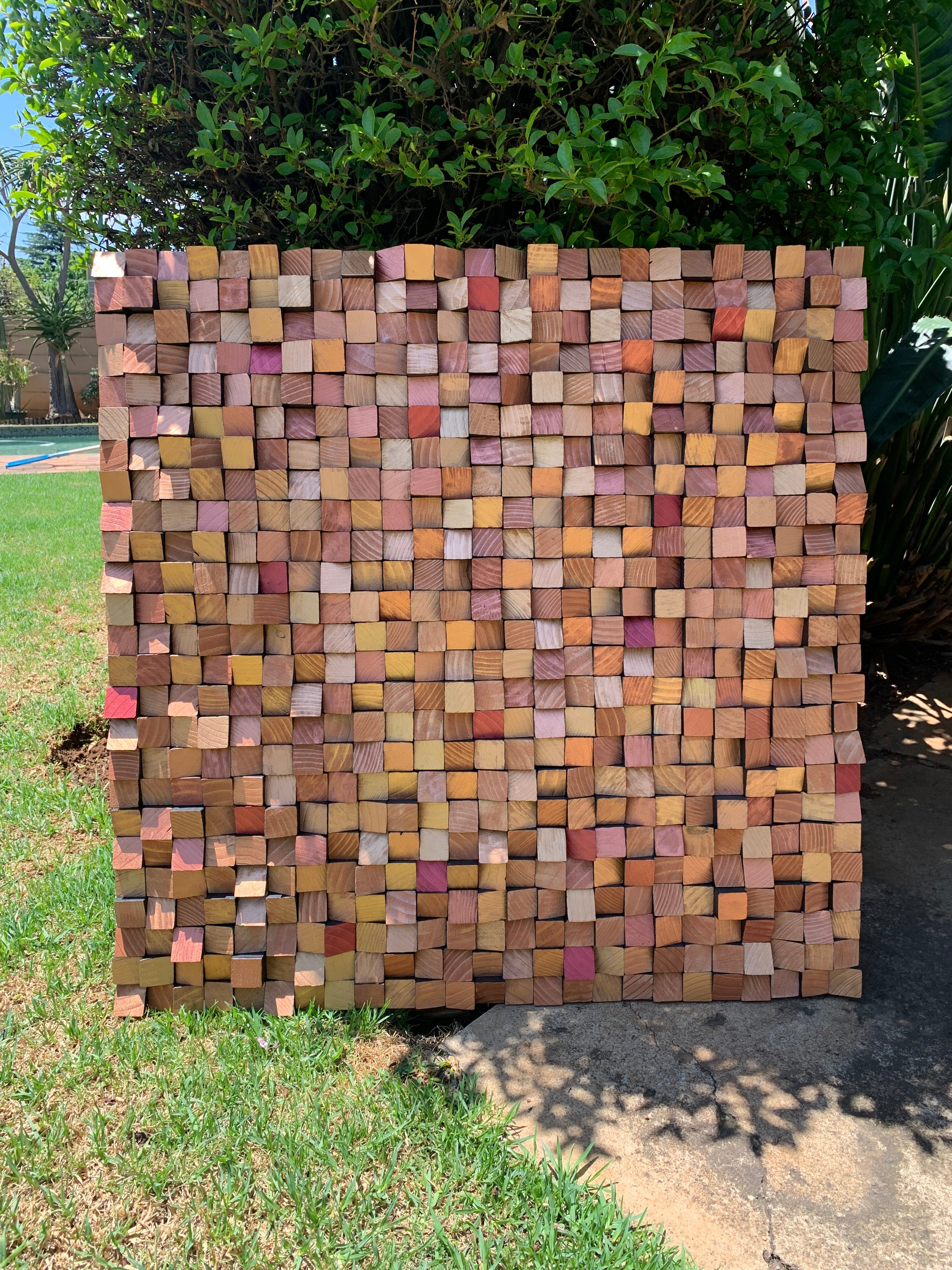 Handmade bronze and gold wood wall art commissioned for a South African movie set, shown outdoors before installation