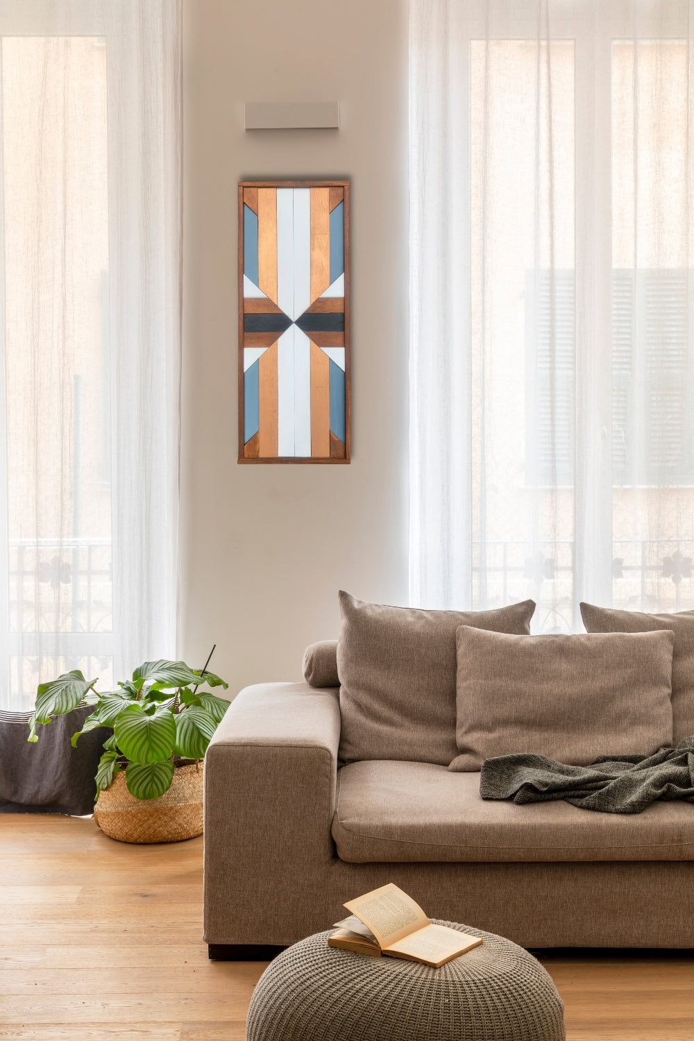 Vertical geometric wooden wall art displayed in a soft neutral living room with natural wood and painted details.