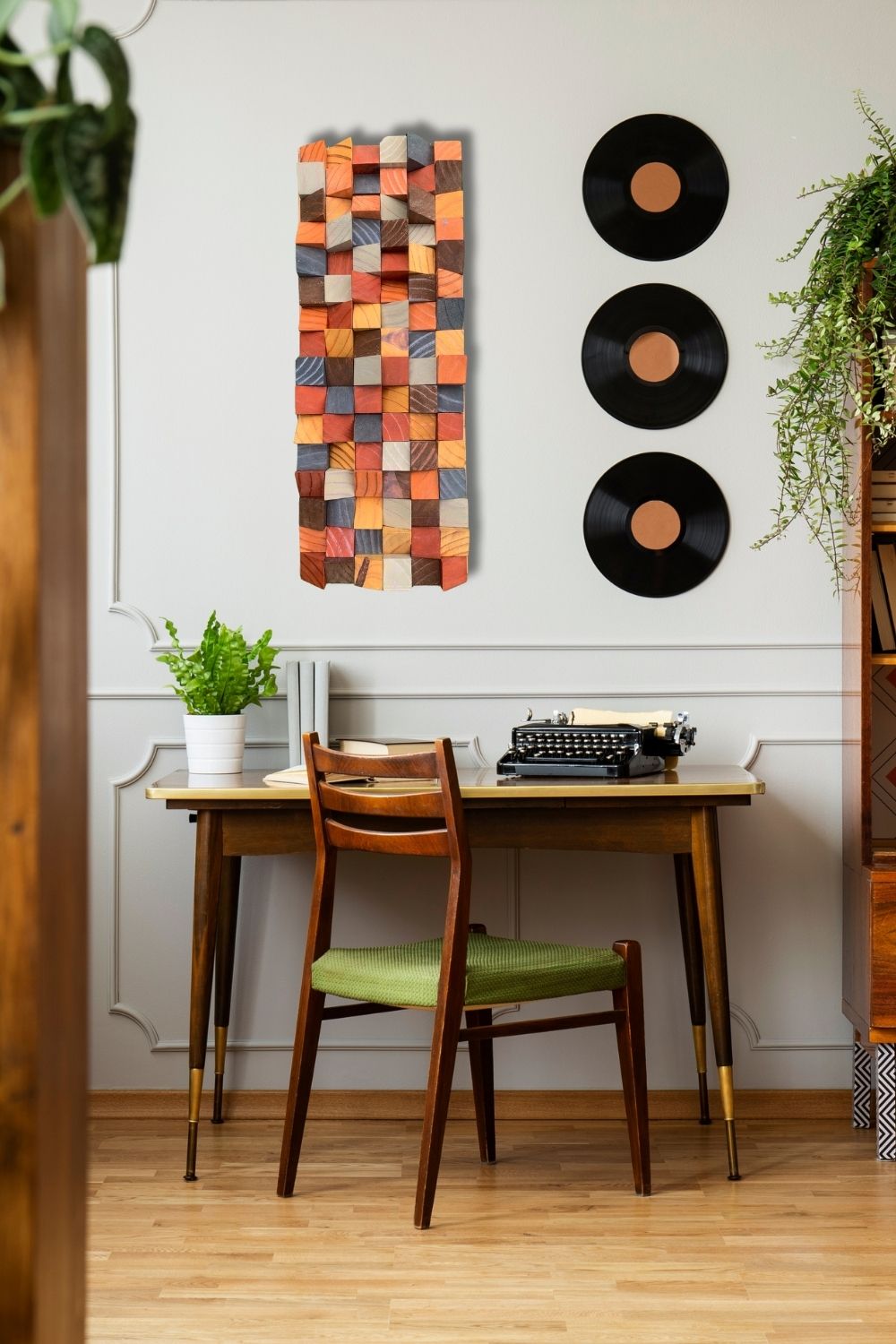 Warm painted wooden block wall art displayed above a vintage desk with record wall decor, plants, and rich natural wood tones.